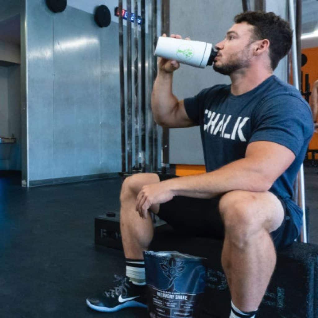 Person trinkt einen Proteinshake im Fitnessstudio